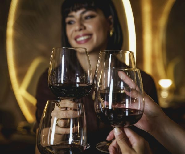 Woman clinking wine glasses celebrating birthday at restauran