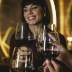 Woman clinking wine glasses celebrating birthday at restauran